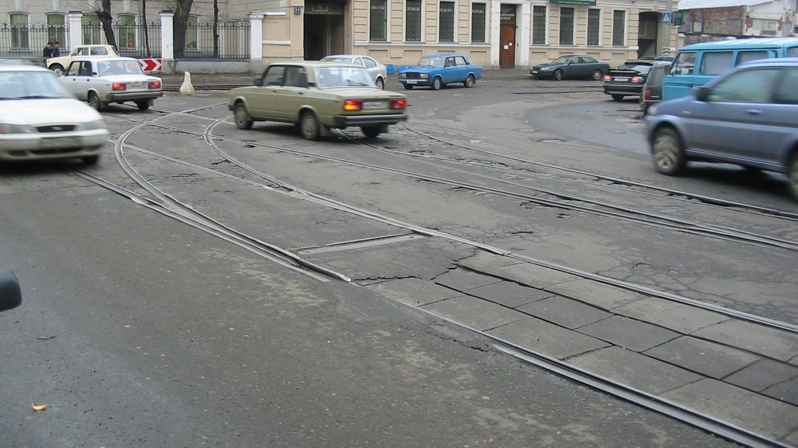 Tram tracks diverging at a street junction in Moscow, with cars passing.