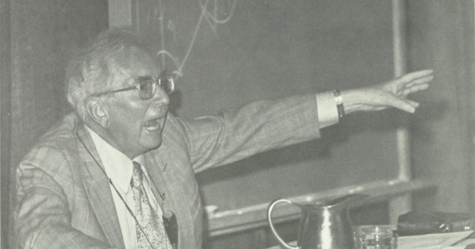 Viktor Frankl lecturing in front of a blackboard, one arm stretched out